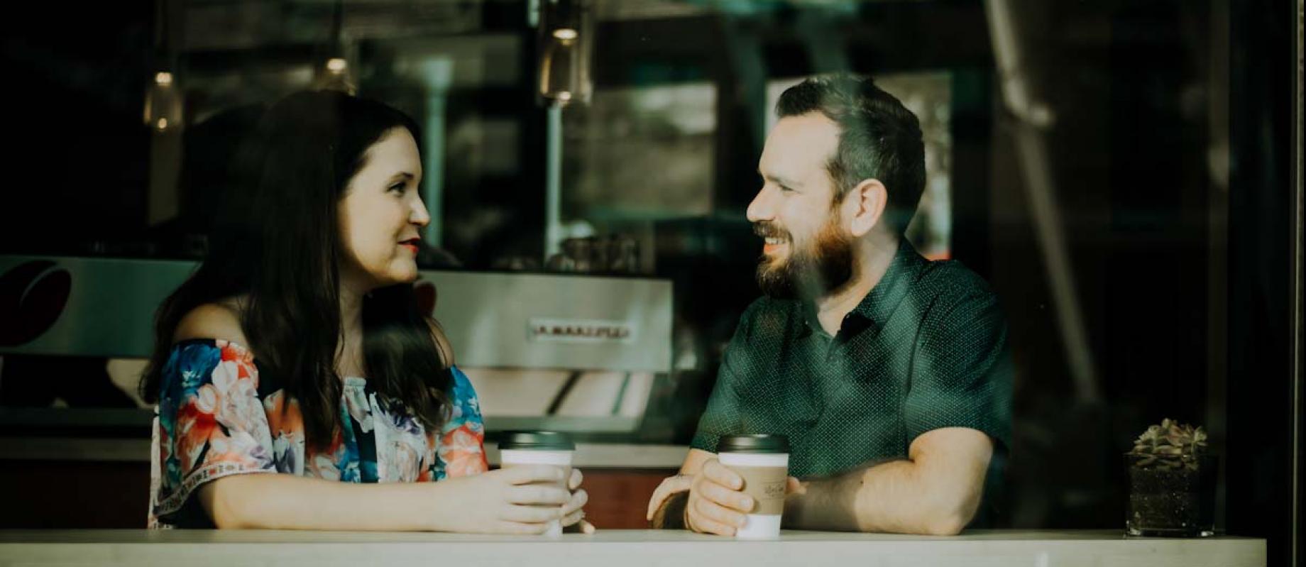 People sitting at a window having coffee and a chat